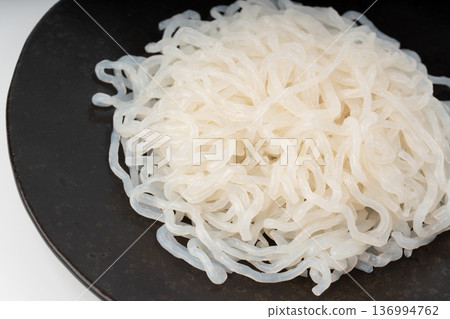 Shirataki or konnyaku pasta on black plate close up. Konjak jelly noodles 136994762