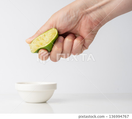 Squeezed lime isolated, squeezed out half green lemon on white background, burnout symbol Squeezed lime isolated, squeezed out half green lemon on white background, burnout symbol 136994767