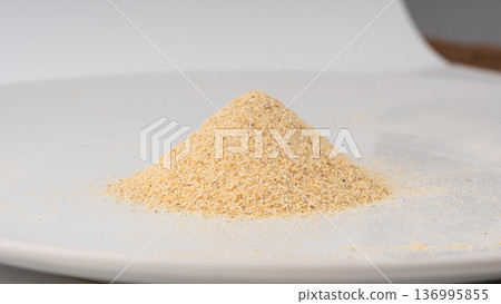 Garlic powder pile isolated, dried granulated chopped crushed garlic on white background 136995855