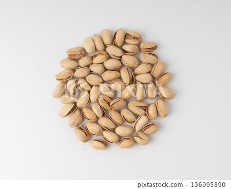 Fried salt pistachio nuts isolated. Baked pistachios pile, roasted green pistache fruit in shell on white Fried salt pistachio nuts isolated. Baked pistachios pile, roasted green pistache fruit in shell on white 136995890