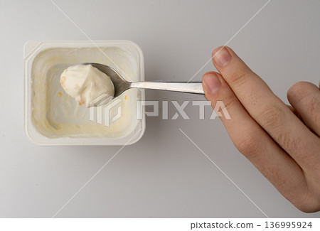 Yogurt cup isolated, yoghurt with orange fruits pieces in plastic pot, spoon in milk pudding Yogurt cup isolated, yoghurt with orange fruits pieces in plastic pot, spoon in milk pudding 136995924