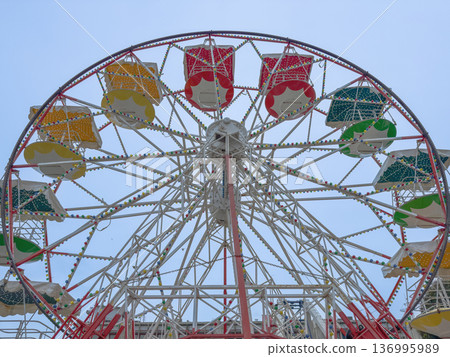 Empty ferris wheel stands still in luna park during daytime hours. 136995989
