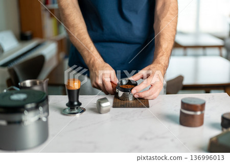 Man Preparing Espresso Dose Using A Portafilter In The Kitchen 136996013