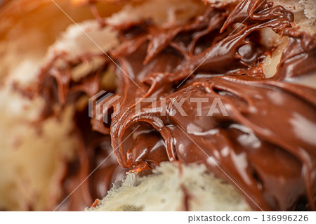 Melted chocolate filling inside flaky croissant macro Melted chocolate filling inside flaky croissant macro 136996226