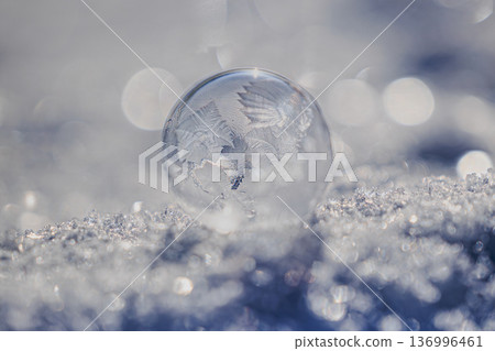 A beautiful winter background with ice balls and bokeh floating on the snow 136996461
