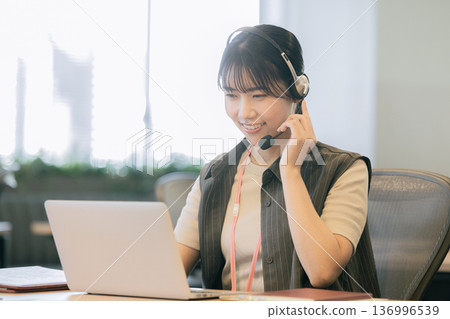 關於收入談話的運營商的一名年輕女子 關於收入談話的運營商的一名年輕女子 136996539