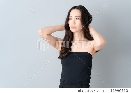 Beauty image of a woman doing skin care on a gray background Beauty image of a woman doing skin care on a gray background 136996760