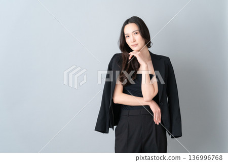 Beauty image of a woman doing skin care on a gray background 136996768