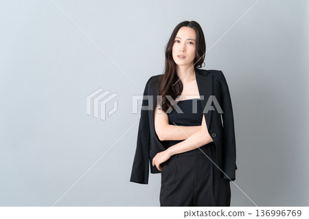 Beauty image of a woman doing skin care on a gray background 136996769