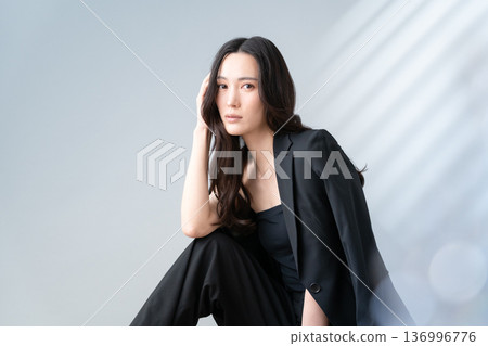 Beauty image of a woman doing skin care on a gray background 136996776