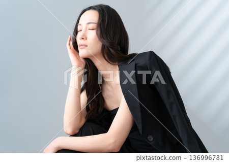 Beauty image of a woman doing skin care on a gray background Beauty image of a woman doing skin care on a gray background 136996781
