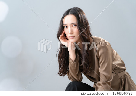 Beauty image of a woman doing skin care on a gray background 136996785