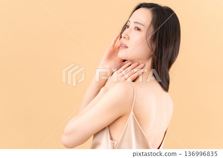 一位女士在米色背景下進行護膚的美麗圖片 136996835