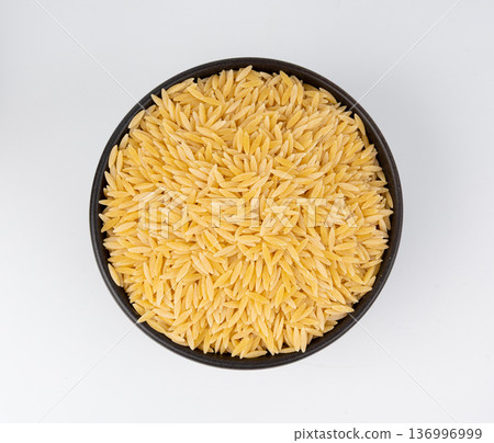 Raw orzo pasta, risoni or kritharaki pile 136996999