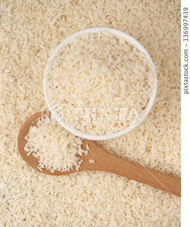 Grated coconut powder. Dry coco flakes pile, shredded desiccated coconut, tropical fruit chips 136997439