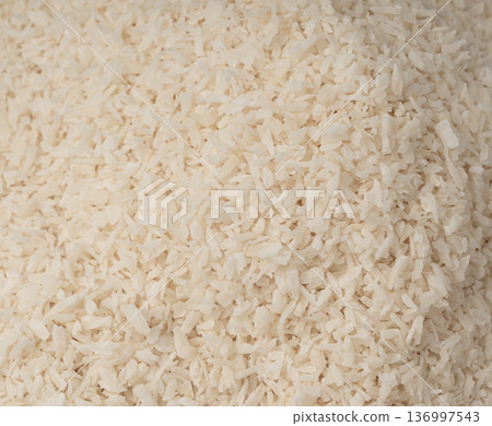 Grated coconut powder. Dry coco flakes pile, shredded desiccated coconut, tropical fruit chips 136997543
