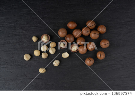 Macadamia nuts isolated. Natural raw peeled macadamia seeds and shells 136997574