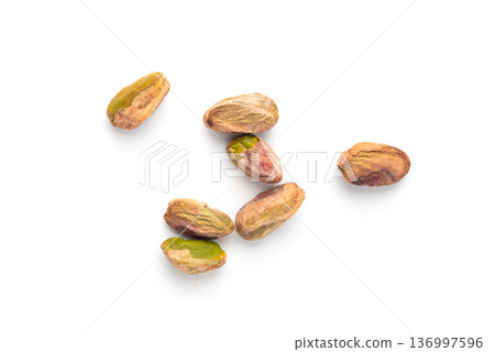 Fried salt pistachio nuts isolated. Baked pistachios pile, roasted green pistache fruits on white Fried salt pistachio nuts isolated. Baked pistachios pile, roasted green pistache fruits on white 136997596