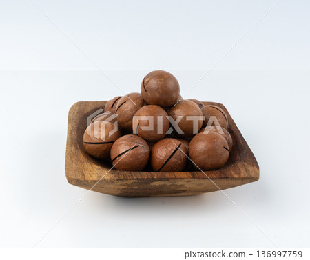 Macadamia nuts isolated. Natural raw peeled macadamia seeds and shells Macadamia nuts isolated. Natural raw peeled macadamia seeds and shells 136997759