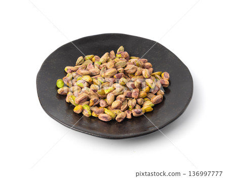 Fried salt pistachio nuts isolated. Baked pistachios pile, roasted green pistache fruits on white Fried salt pistachio nuts isolated. Baked pistachios pile, roasted green pistache fruits on white 136997777