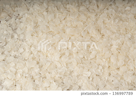 Raw flattened rice textured background. Dry rice flakes or poha pattern, Indian breakfast food 136997789