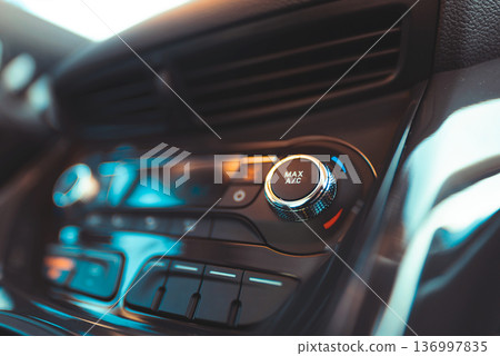 Man turning on car air conditioning system 136997835