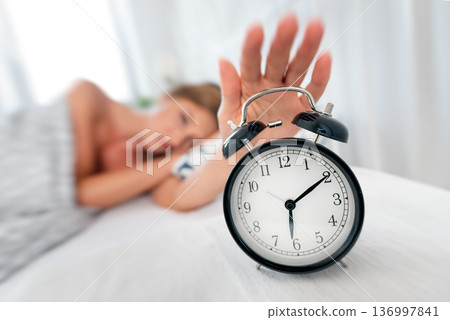 Analog alarm clock. Woman sleeping in bed Analog alarm clock. Woman sleeping in bed 136997841