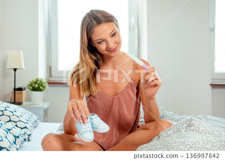 Woman holding pregnancy test in happiness Woman holding pregnancy test in happiness 136997842
