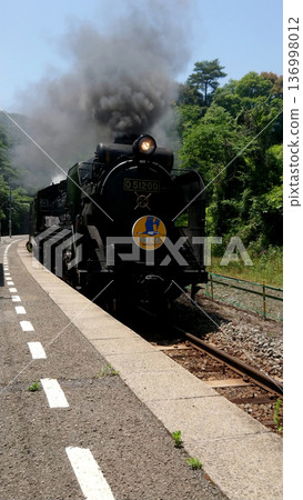 Steam locomotive D51200 spewing black smoke as it runs along a local line - a promotion for railway tourism Steam locomotive D51200 spewing black smoke as it runs along a local line - a promotion for railway tourism 136998012