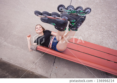 Crazy woman on bench wearing roller skates 136998214