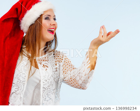 Excited woman in christmas santa hat Excited woman in christmas santa hat 136998234