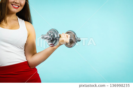 Woman lifting dumbbells Woman lifting dumbbells 136998235