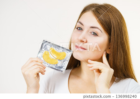 Woman ready to apply gold eye patches 136998240