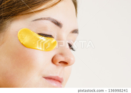Woman with gold patches under eyes 136998241