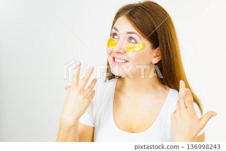 Woman with gold patches under eyes 136998243