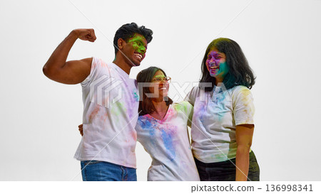 Young Indian friends celebrating Holi with joy isolated on white. Young Indian friends celebrating Holi with joy isolated on white. 136998341