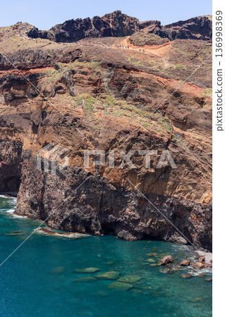 Sheer volcanic cliffs at Baia d Abra Ponta de Sao Lourenco Madeira meet calm turquoise Atlantic Sheer volcanic cliffs at Baia d Abra Ponta de Sao Lourenco Madeira meet calm turquoise Atlantic 136998369
