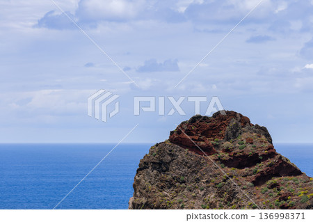 Rocky islet near Madeira north coast Portugal, wide seascape with rugged cliffs, turquoise swells Rocky islet near Madeira north coast Portugal, wide seascape with rugged cliffs, turquoise swells 136998371