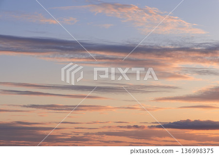 Pastel sunset cloudscape with peach and lavender streaks, layered clouds and wide copy space Pastel sunset cloudscape with peach and lavender streaks, layered clouds and wide copy space 136998375