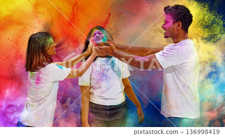 Friends laughing while covering face with colorful Holi powder. Friends laughing while covering face with colorful Holi powder. 136998419
