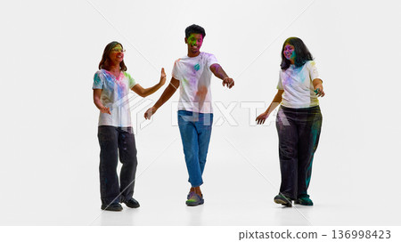 Group of friends dancing during Holi celebration isolated Group of friends dancing during Holi celebration isolated 136998423