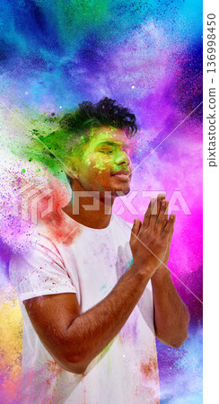 Young man praying with colorful powder explosion background. 136998450