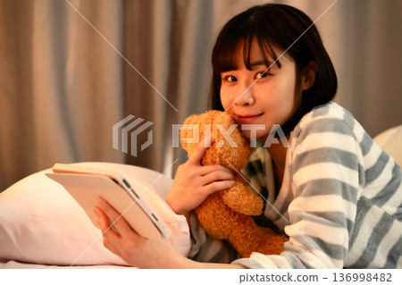 臥室裡，有一台平板電腦和一隻熊 136998482