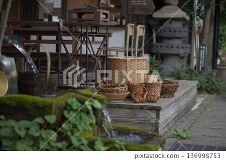 A nostalgic Japanese scene: bamboo baskets and stone water trays lined up in front of a store A nostalgic Japanese scene: bamboo baskets and stone water trays lined up in front of a store 136998753