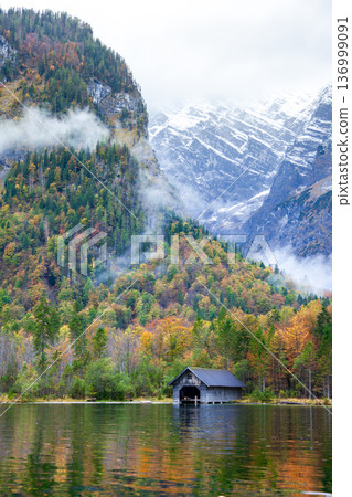 Autumn scenery of Königssee in Germany and the tranquil wooden boat docks along its shore. 136999091