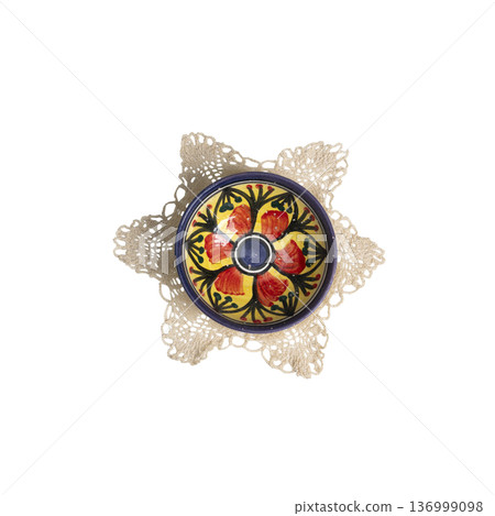 a small hand-painted bowl on a crocheted doily a small hand-painted bowl on a crocheted doily 136999098