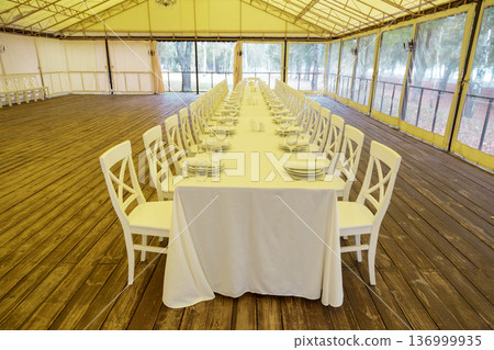 Long banquet table in event tent 136999935