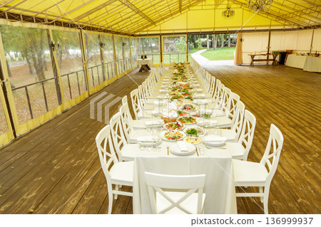 Long banquet table in event tent Long banquet table in event tent 136999937