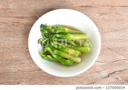 fried Kailaan Chinese kale dressing oyster sauce with chop garlic and salty fish on bowl 137000034