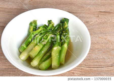 fried Kailaan Chinese kale dressing oyster sauce with chop garlic and salty fish on bowl 137000035